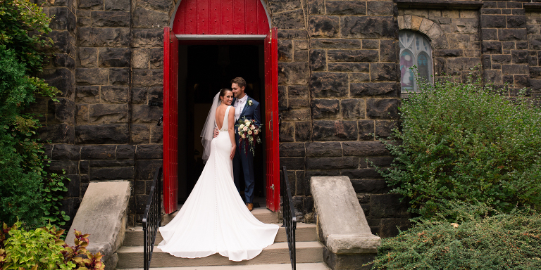 bride and groom standing in red doorway at church of the ascension pittsburgh