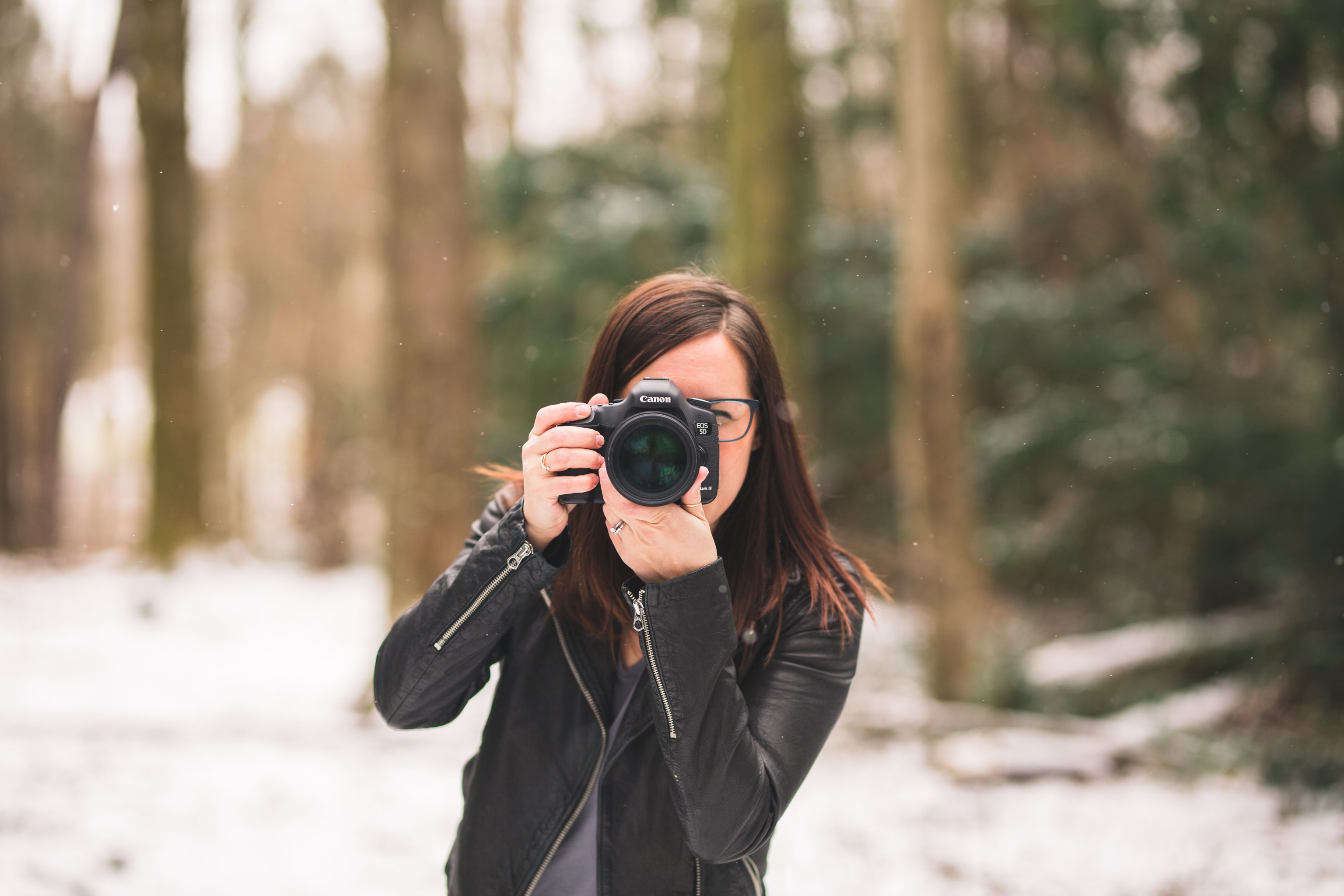 photographer wearing madewell leather jacket holding camera